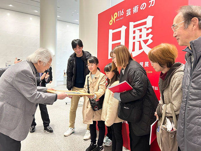 210人目に来場した伊藤有沙さん（小6）に藤森兼明中部日展会代表の画がプレゼントされました。
